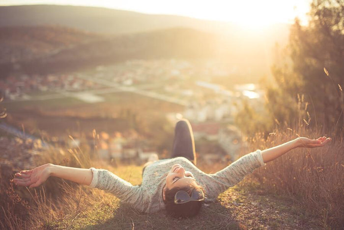 women lays in sun above a city